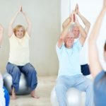 A group of elderly people exercising together on balance balls